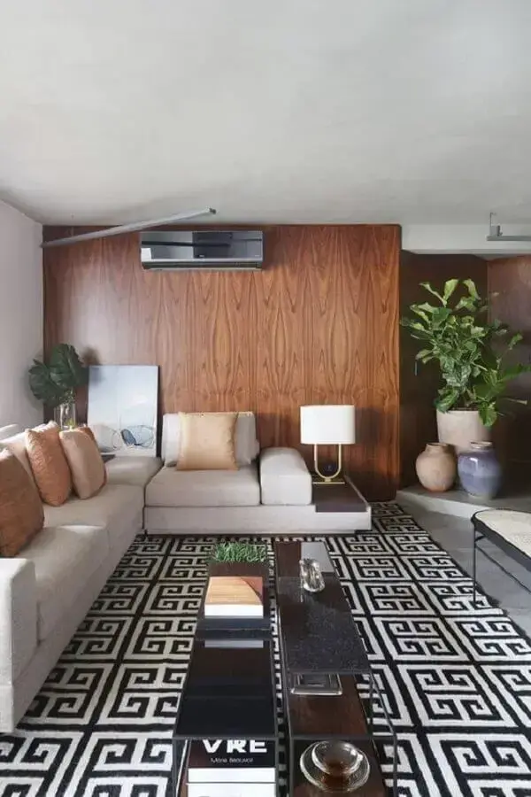 Parede de madeira para sala decorada com tapete geométrico e almofadas para sofá cinza claro Foto Casa Vogue