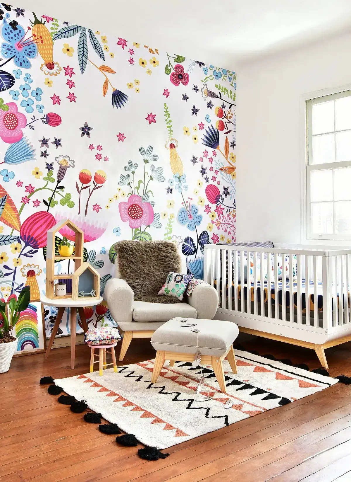 Quarto de bebê colorido moderno com papel de parede floral e móveis retrô