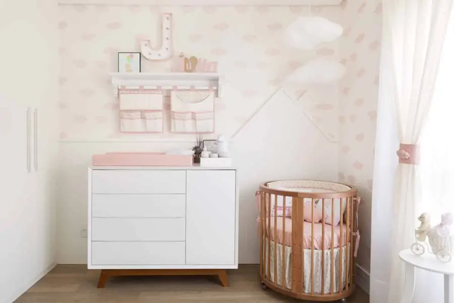 Quarto de bebê feminino decorado com papel de parede delicado e cômoda branca pequena Foto Pinterest