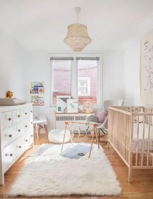 Quarto de bebê minimalista com tapete de lã branco e brinquedos no chão