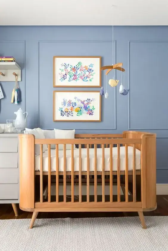 Quarto de bebê moderno com parede azul e berço de madeira