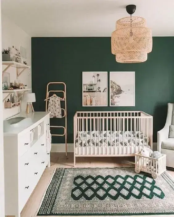Quarto de bebê moderno com parede verde esmeralda e móveis brancos