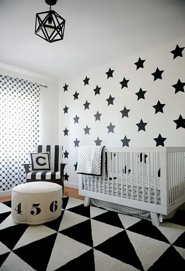 Quarto de bebê moderno em preto e branco com papel de parede de estrelas e tapete geométrico