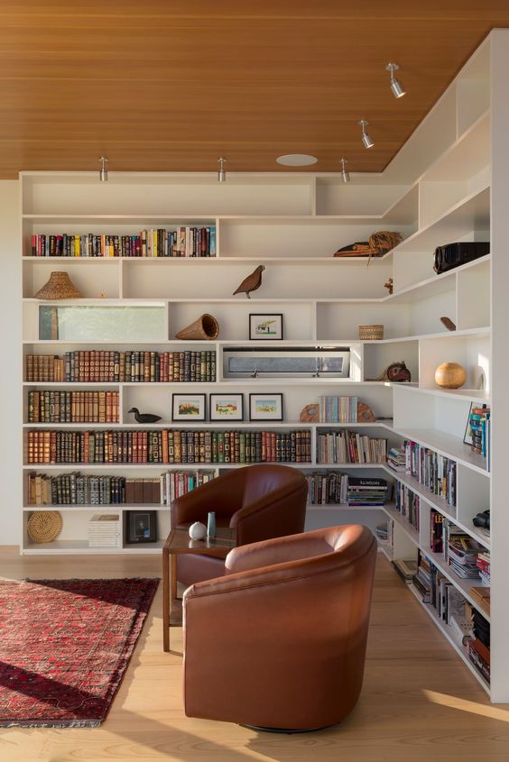 Sala com estante de canto planejada pra livros e enfeites