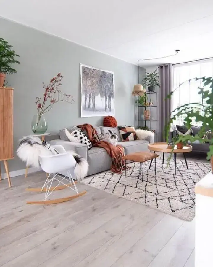 Sala de estar cinza e branco decorada com vasos de planta e cadeira eames de balanço  Foto M-Habitat.fr