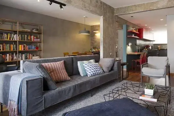 Sala de estar decorada com almofadas grandes e sofá cinza