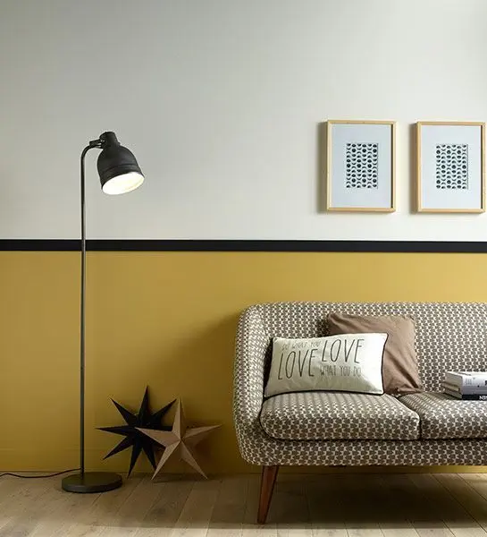 Sala de estar retrô com rodameio preto e parede mostarda