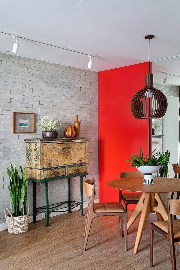 Sala de jantar decorada com parede tijolinho cinza e cadeira cor caramelo Foto Casa de Valentina