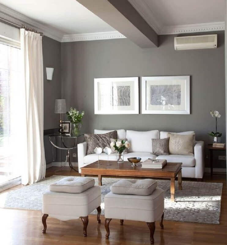 Sala pintada de cinza e branco decorada com mesa de centro de madeira  Foto El Mueble
