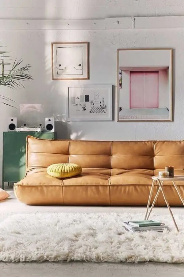 Sala simples decorada com sofá cor caramelo sem braço e tapete felpudo Foto Jeito de Casa