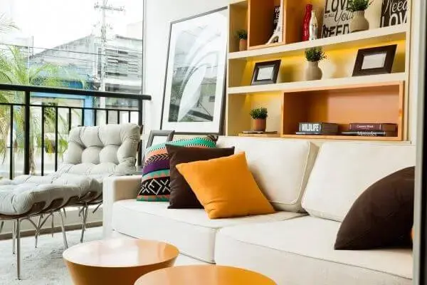 Sofá bege com almofadas grandes e coloridas para decoração clássica
