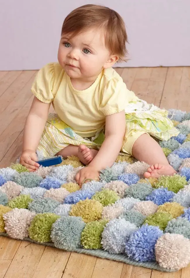 Tapete de lã com pompons para quarto infantil