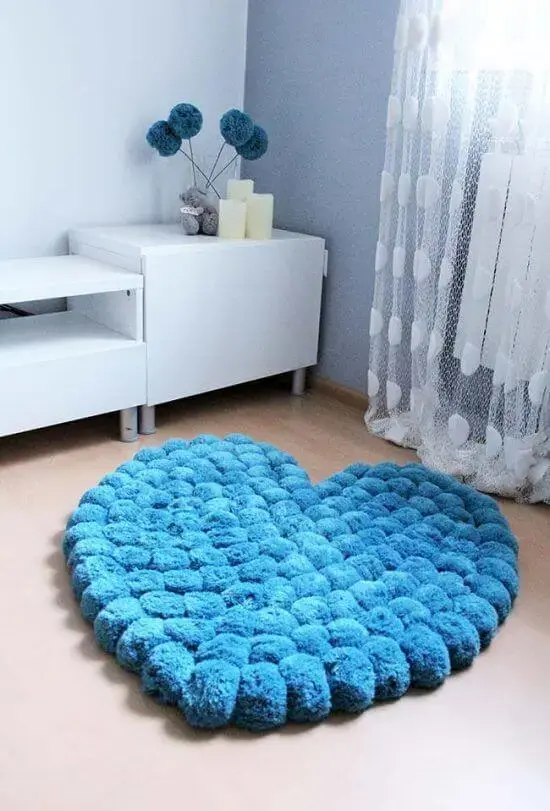 Tapete de lã feito de pompom no formato de coração azul