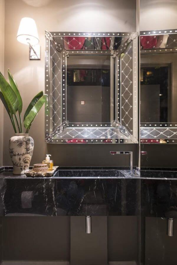 Banheiro com bancada de mármore e espelho chique