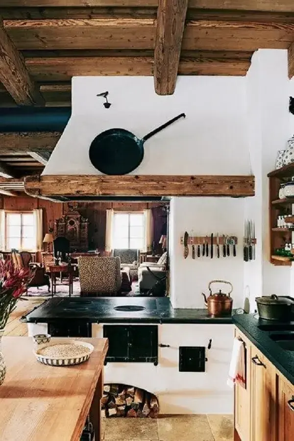 Área gourmet com fogão a lenha e armários planejados