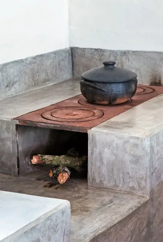 Área gourmet com fogão a lenha e revestimento de cimento queimado