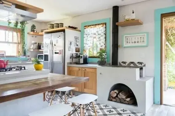 Área gourmet com fogão e lenha e mesa de madeira completa