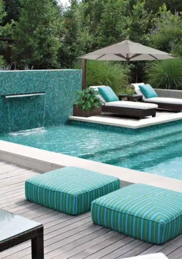 Área para piscinas modernas no quintal com guarda sol perto das espreguiçadeiras