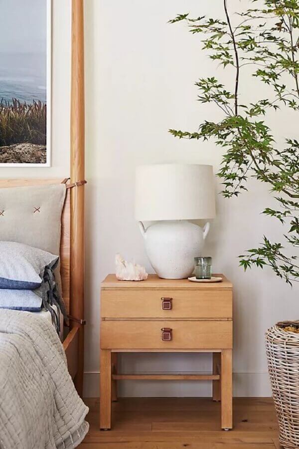 Abajur para criado mudo de quarto decorado com vaso de plantas e moveis de madeira Foto Anthropologie