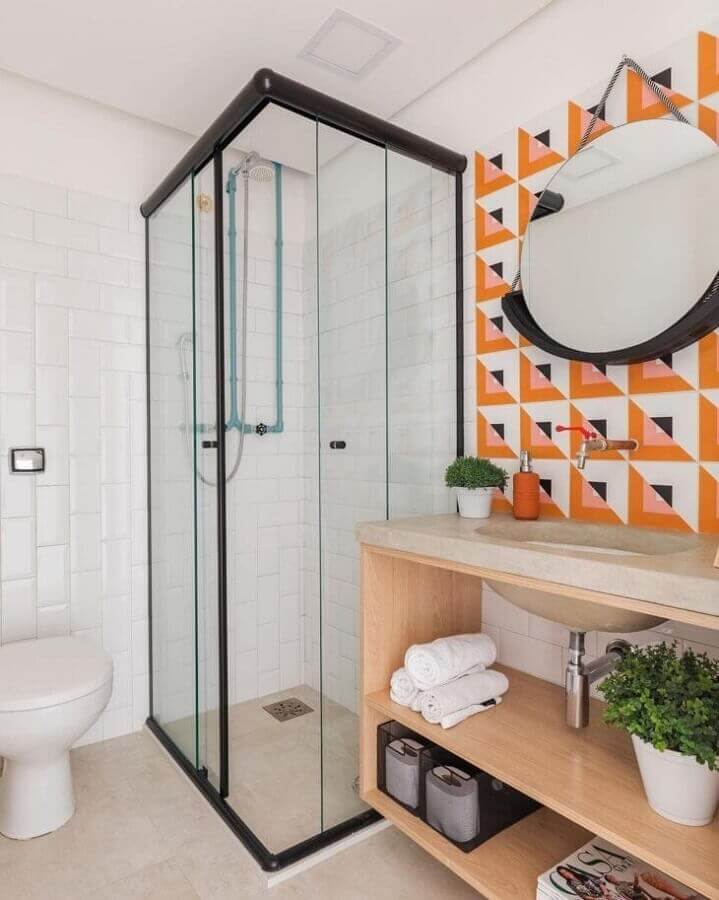 Banheiro simples e bonito decorado com revestimento colorido e espelho redondo Foto SP Estúdio