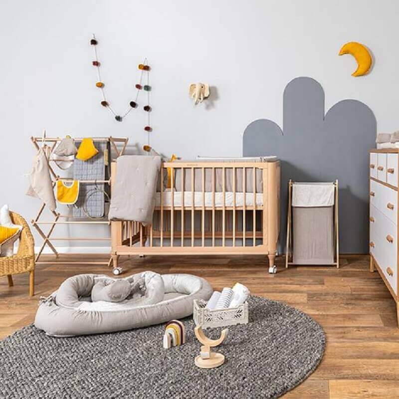 Berço de bebê de madeira para quarto simples decorado com tapete redondo cinza Foto Baby Bedding Design