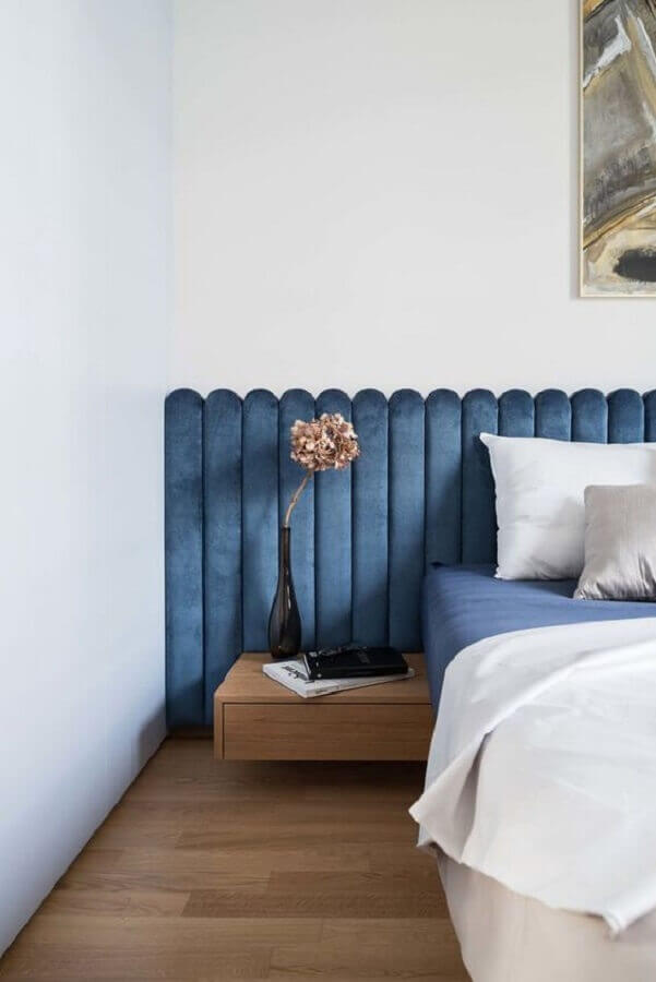 Cabeceira de cama box estofada azul para quarto branco decorado com criado mudo pequeno Foto Dwell