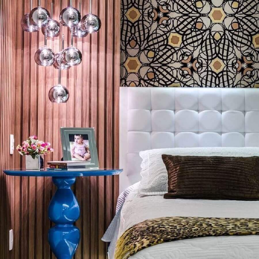 Cama com cabeceira almofadada branca para decoração de quarto com mesa lateral azul Foto Carla Sampaio