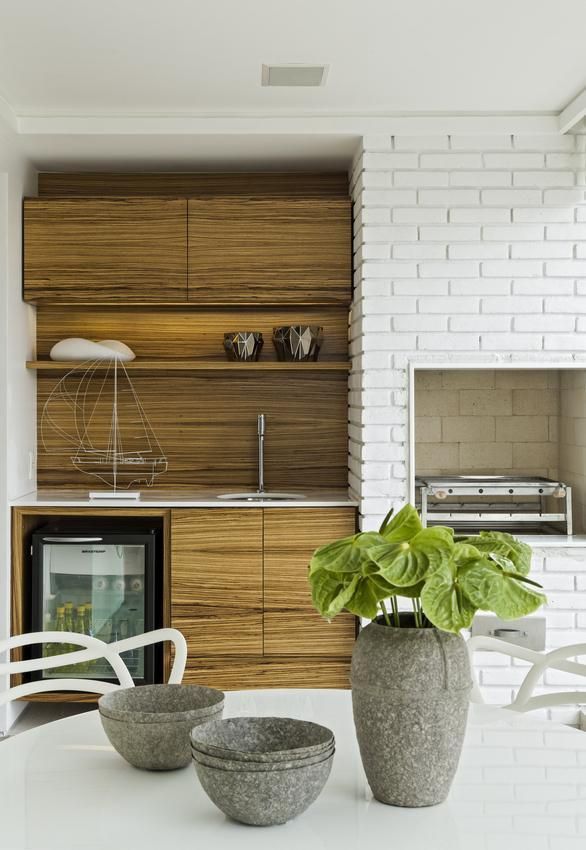 Churrasqueira pequena revestida com tijolinho branco moderno e gabinete planejado de madeira