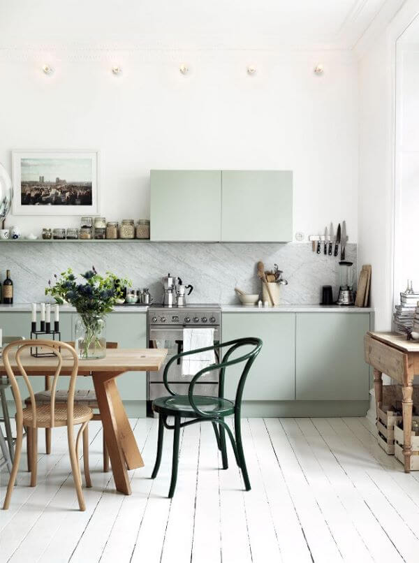 Cozinha com armário verde sage e mesa de madeira
