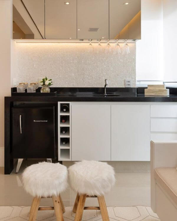 Cozinha com revestimento cor prata e branco combinando com armário suspenso espelhado