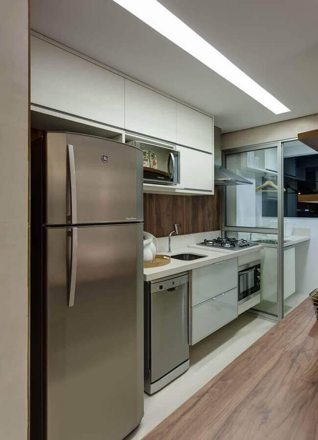 Cozinha de apartamento decorada com gabinete branco e armario aereo Foto Renata Basques