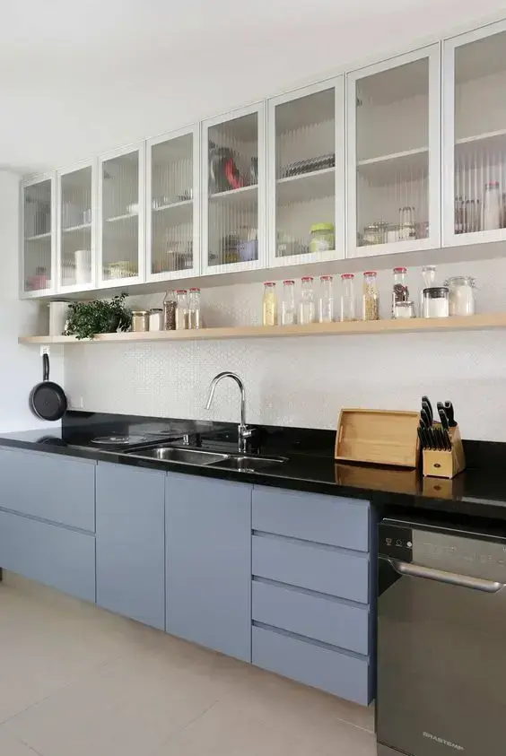 Cozinha moderna com armários azuis e armário de vidro suspenso
