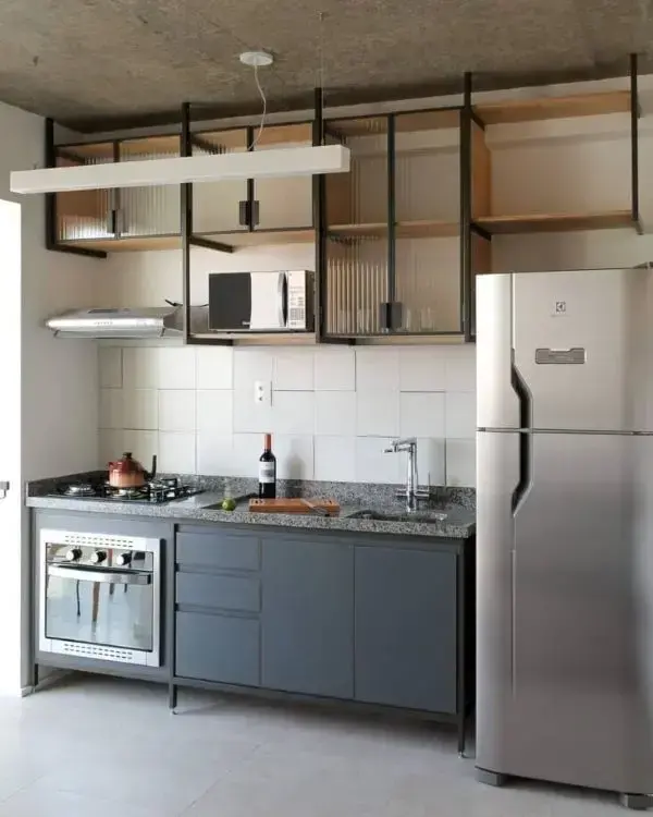 Cozinha pequena com armário de vidro e gabinete azul