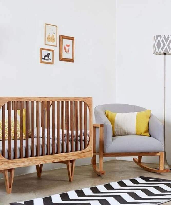 Decoração clean para quarto de bebê com poltrona cinza e berço de madeira Foto Love Property