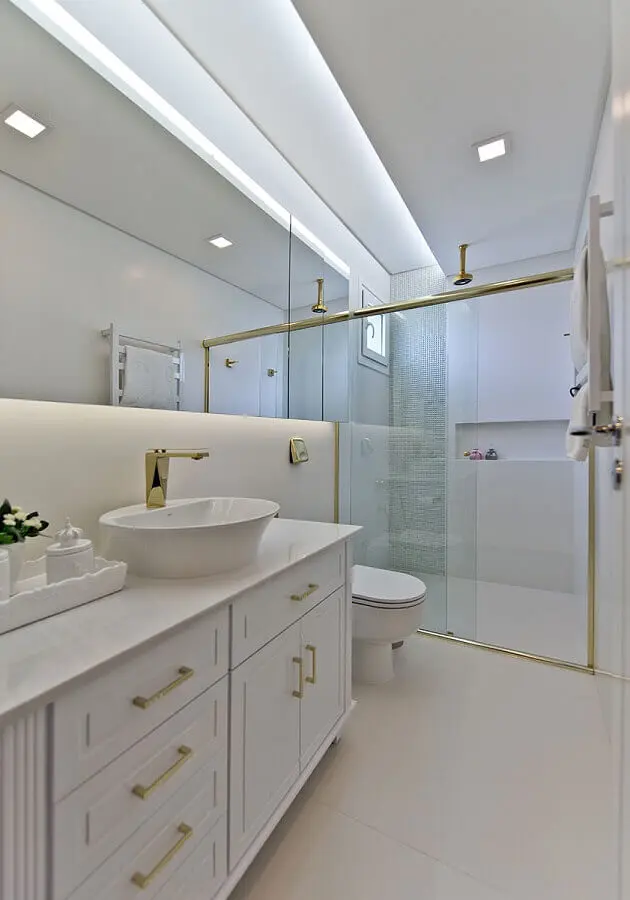 Decoracao sofisticada para banheiro com gabinete branco e detalhes dourados Foto Espaço do Traço Arquitetura