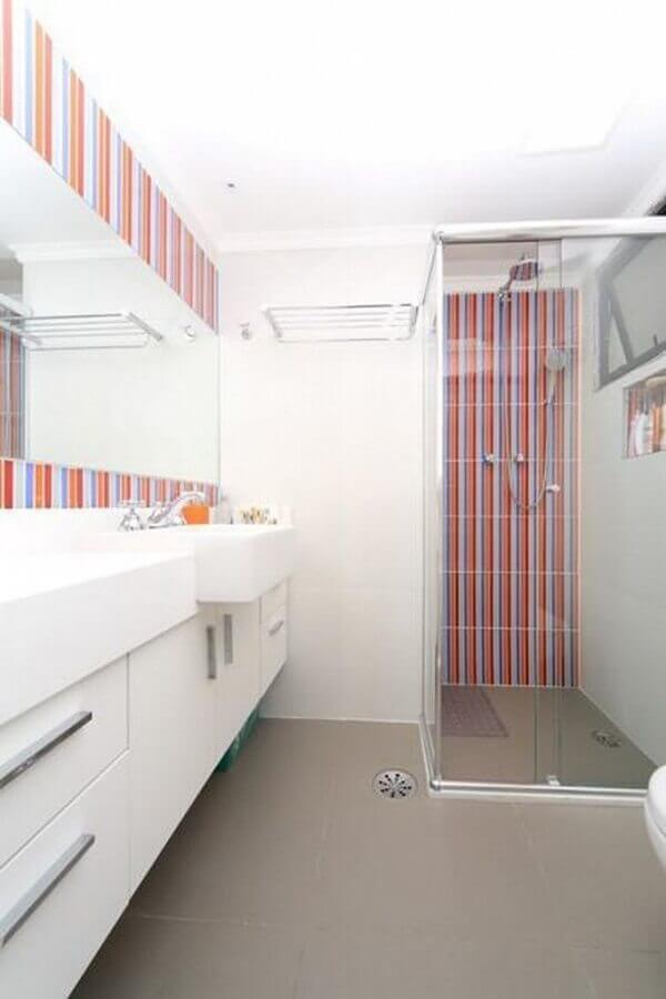 Gabinete branco para banheiro decorado com revestimento listrado Foto Olividros