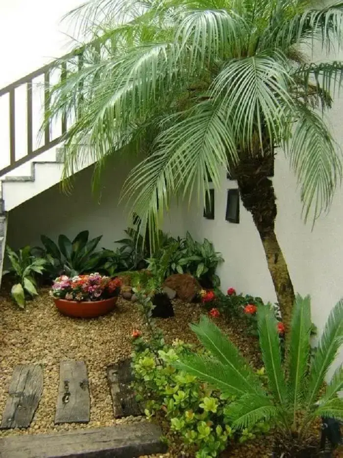 Ideias para área externa simples: jardim com pedras e vasos de plantas. Fonte: MC3 Arquitetura
