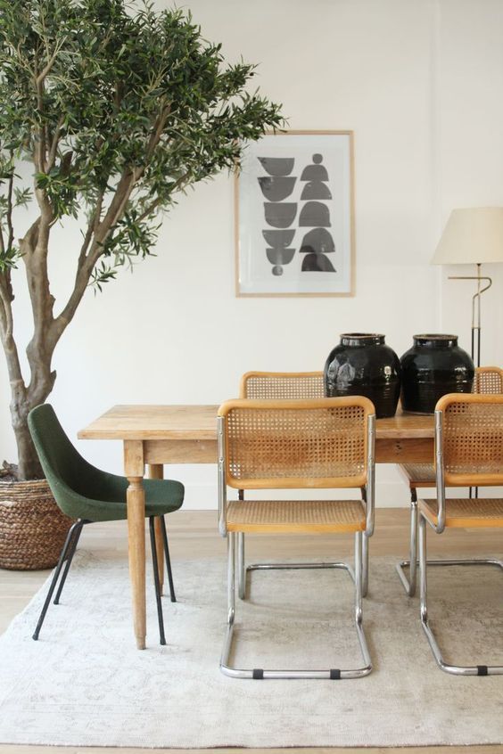 Mesa de jantar de madeira com cadeira cesca e poltrona verde