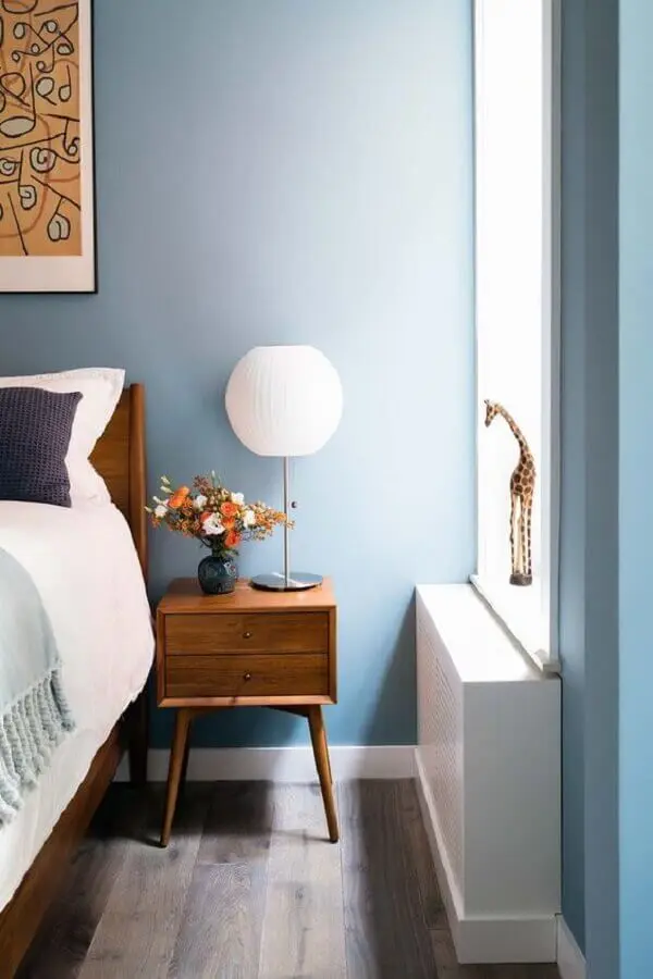Quarto azul decorado com móveis de madeira e abajur para criado mudo Foto Amy Barkow