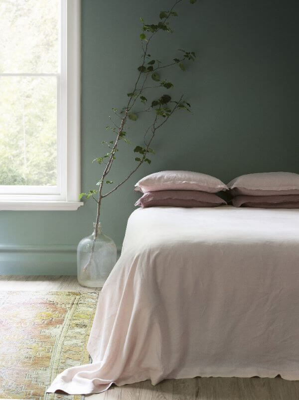 Quarto verde sage com roupa de cama rosa