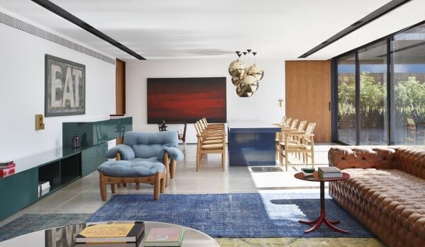 Sala de estar com decoração azul e sofá de couro caramelo