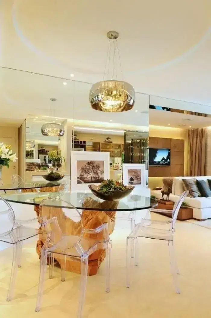 Sala de jantar de apartamento de luxo com parede espelhada e mesa de madeira rústica. Fonte: Quitete &amp; Faria