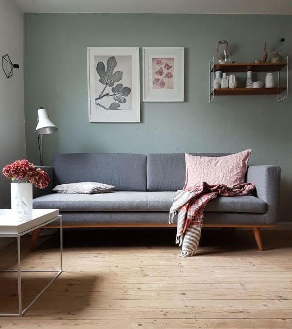 Sala pequena com parede verde sage e sofá cinza