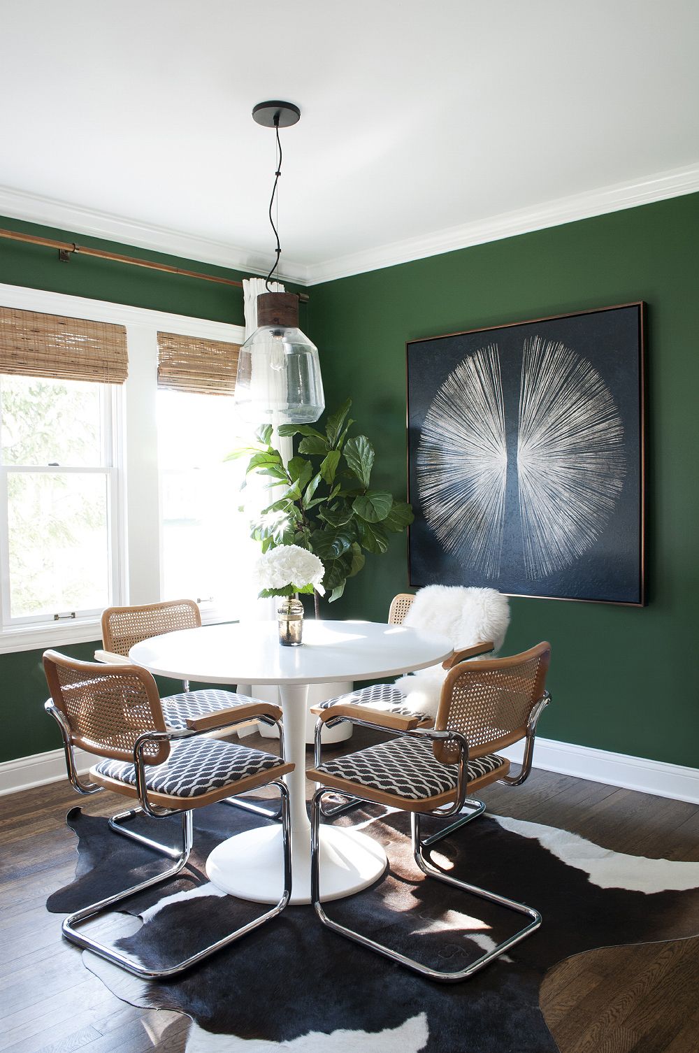 Sala verde com mesa redonda e cadeira cesca