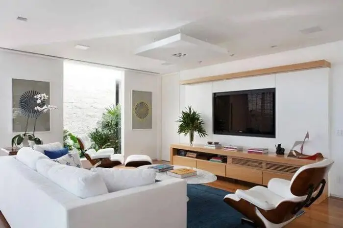 Sofá branco e rack moderno para sala de estar. Projeto de Paola Ribeiro