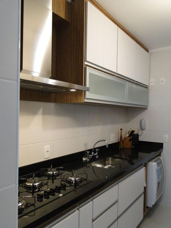 Cozinha moderna com bancada de granito e armário aéreo de vidro