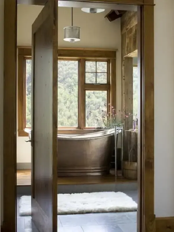 A banheira simples de cobre foi posicionada próxima da janela do imóvel. Fonte: Decor Fácil