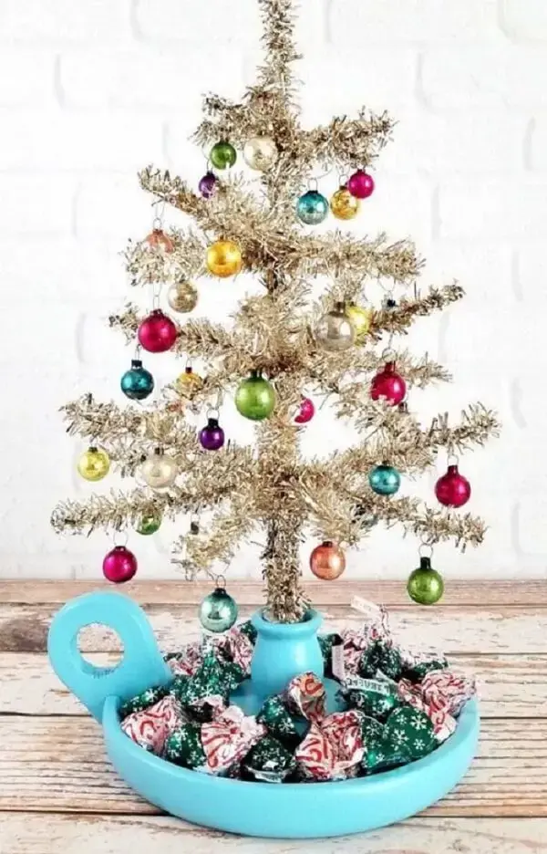 A base da árvore de natal dourada pode conter um suporte para acomodar balas e doces. Fonte: Decor Fácil