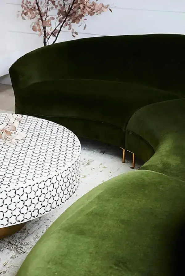 A mesa de centro redonda se encaixa perfeitamente na sala de estar com sofá curvo. Fonte: Anthropologie