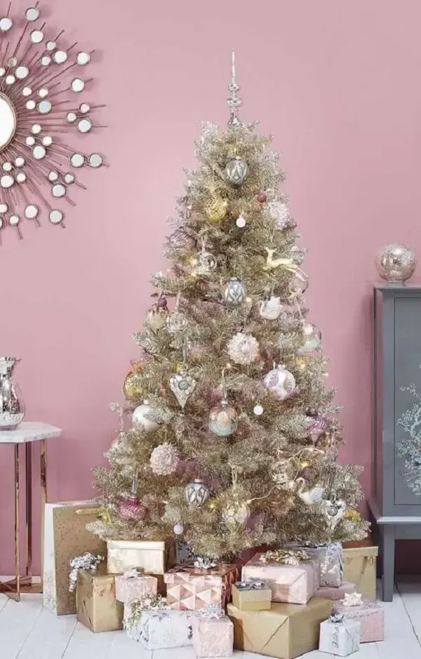 A árvore de natal rose e dourado se contrasta com a parede do ambiente. Fonte: Decor Fácil